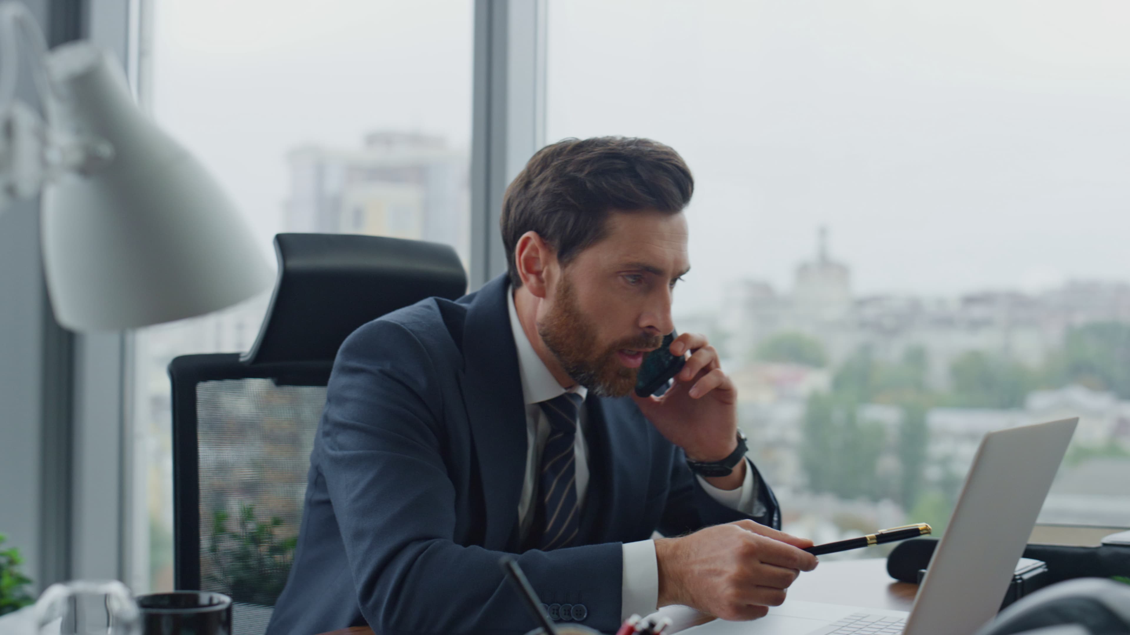 Business owner handling a phone call beside a laptop